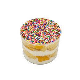 A clear plastic cup filled with a layered dessert, featuring alternating layers of yellow cake and vanilla Chantilly cream, topped with a dense layer of rainbow dot sprinkles, isolated on a white background.